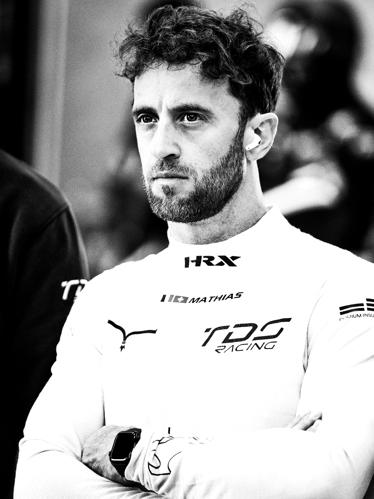 Black-and-white portrait of Mathias Beche in his TDS Racing suit at MotorLand Aragón